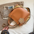 Secchiello arancione zenzero con tracolla a righe e ciondolo floreale su beige - Arancione