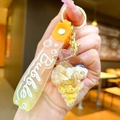 Détail macro d'un porte-clés en résine avec coquillage et dragonne orange vif - Corde Dégradée [Jaune] Petit Escargot + Conque