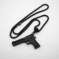 Detailed close-up of a matte black pistol pendant on a stainless steel chain necklace - 4mm 60cm Box Pearl Chain / Black