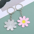 Dettaglio del portachiavi a margherita smaltata con petali rosa e retro in metallo - Rosa