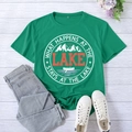 Detailed view of lake-themed graphic print on green cotton t-shirt with wood background - S / Dark Green (White Font)