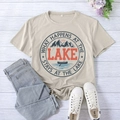 Flat lay of a beige lake-themed T-shirt with vintage print on light wood background - S / Sand (Black Font)