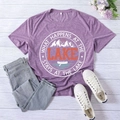 Flat lay of purple Lake printed t-shirt with jeans, shoes and floral decor on wood - S / Purple (White Font)