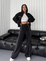 Détail d'un survêtement noir avec liserés blancs sur les manches et pantalon large - S / Haut Et Bas / Noir