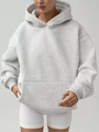 Close-up of light gray oversized hoodie featuring a kangaroo pocket and ribbed cuffs - Silver Gray