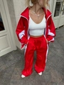 Dettaglio della tuta bicolore rossa e bianca con giacca zip e pantaloni sportivi larghi - Taglia S / Rosso