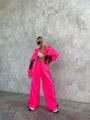 Dettaglio della tuta rosa neon con inserti neri a contrasto e trama in nylon premium - Taglia S / Rosso rosa