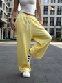 Dettaglio dei pantaloni sportivi giallo chiaro a gamba larga con coulisse e elastico - S / Giallo