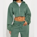 Detail of sage green cropped zip hoodie with raw hem design and drawstring jogger set - S / Green