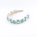 Close-up of luxury sponge headband with blue crystals and white pearls on blue fabric - Pink Style (E)