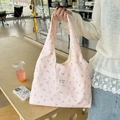 Détail du sac cabas en toile rose à fleurs avec motifs floraux et étiquette de marque - Rose Floral