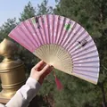 Pink cherry blossom folding fan with carved bamboo ribs and dark red tassel detail - Pink Purple Traditional Architecture Style (Smiling Fan 22)