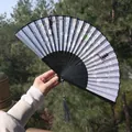 Handheld folding fan with cherry blossom pattern and grey tassel in sunlight - Grey-Blue Cherry Blossom Architectural Style (Yixiao Fan 97)