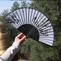 Classic folding fan with ink lotus painting and black silk tassel in outdoor sunlight - Ink Wash Lotus & Dragonfly Fan Style (No. 77)