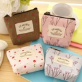 Floral canvas coin purses in four colors with zipper closure on a wooden desk - Blue