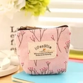 Monedero floral rosa de lona con cremallera y etiqueta lifestyle sobre madera - Rosa