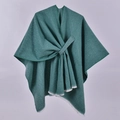 Dettaglio dello scialle in maglia verde petrolio con trama spessa e drappeggio incrociato - Verde con Frange Bianche