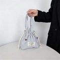 Detail der blau gestreiften Canvas-Tasche mit roter Schleifenstickerei und Hasenaufnäher - Blau Gestreift Roter Bogen