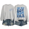 Close-up of Boy Mom Era print on grey sweatshirt with blue lettering and denim shorts - Gray