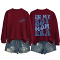 Detail of burgundy Boy Mom Era sweatshirt with blue lettering and distressed denim shorts - Burgundy