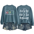 Detail view of the quote on back of blue-gray hospice nurse sweatshirt with denim shorts - Blue (White Print)