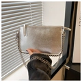 Dettaglio della borsa metallizzata argento con bordi borchiati e tracolla a catena - Argento