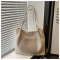 Detail der gestrickten beigen Tragetasche mit Ledertasche und geprägtem Modetext - Gebrochenes Weiß
