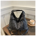 Nahaufnahme der grauen Polka-Dot-Tasche mit schwarzen Schleifen auf einem Holztisch - Schwarzer Polka Dot