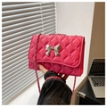 Macro detail of pink quilted faux leather surface with a silver metal bow buckle - Rose Pink