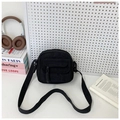 Detalle del bolso bandolera mini de pana negra con tirador de cuerda y correa tejida - Negro