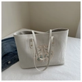 Dettaglio della borsa tote color crema con ricamo floreale e rivetti dorati - Bianco