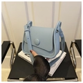 Detalle del bolso bandolera de piel granulada azul claro con solapa y hebilla redonda - Azul