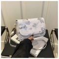 Detail van de vlinderprint op een crossbodytas met goudkleurige metalen sluitingen - Paars
