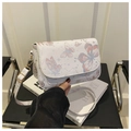 Close-up van de witte leren crossbodytas met elegante roze en blauwe vlinderprints erop - Roze