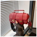 Detail der roten Zylindertasche mit Lederstruktur, Nieten und goldenen Verschlüssen - Rot