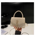 Détail du sac à main tissé beige avec logo métallique, pompon doré et rabat scintillant - Doré
