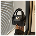 Close-up of black mini box bag featuring a white butterfly ornament and golden chain strap - Black