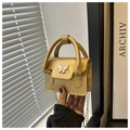 Detailed close-up of a mini gold crossbody bag featuring a white butterfly ornament and chain - Gold