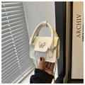 Detail of white mini handbag featuring butterfly metal accent and gold chain strap - White