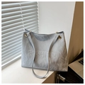 Detalle del bolso tote gris claro con textura arrugada y logo FASHION en relieve - Azul