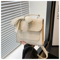 Detail of a creamy white handbag with pleated leather texture and a large stylish bow - White