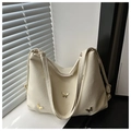 Detail of cream oversized tote bag with gold butterfly accents and textured leather finish - White