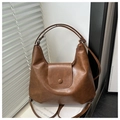 Dettaglio della borsa hobo marrone in pelle PU vintage con fibbia magnetica su bianco - Marrone