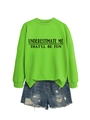 Dettaglio della felpa verde neon con stampa e pantaloncini in denim strappati stesi - Verde Neon (Carattere Nero)