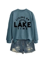 Detail of blue Living on Lake Time sweatshirt paired with distressed denim shorts - Blue Sweatshirt (Black Font)