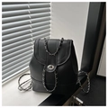Detailed shot of a black leather backpack featuring a silver chain strap and twist lock - Black