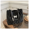 Detail of black pleated tote bag with silver chain, pearl strap and butterfly charm - Black