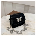 Detail of black velvet mini bag with silver butterfly clasp and fine metal chain strap - Black