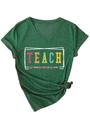 Close-up of deep green V-neck T-shirt featuring a colorful 'TEACH THEM TO BE KIND' print - Retro Green (White Graphic)