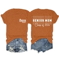 Détail de l'imprimé Senior Mom 2026 sur un t-shirt orange et un short en jean usé - Orange Brûlé (Police Blanche)